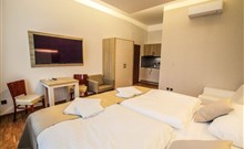 BURČÁKFEST ZNOJMO 2025 - Hotel MARIEL - Pohled z manželské postele na televizi v pokoji hetelu Mariel.